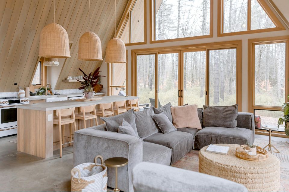 Luxurious wood cabin in the heart of the woods, featuring large windows, soft lighting, and inviting rustic details for a restful escape.